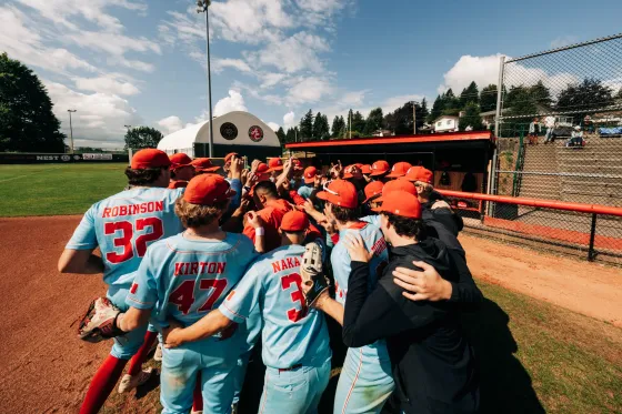 Abbotsford Cardinals players dogpile in celebration after winning the provincial championship.