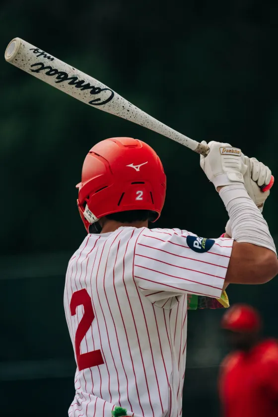 An Abbotsford Cardinals hitter mid-swing, seen from behind.