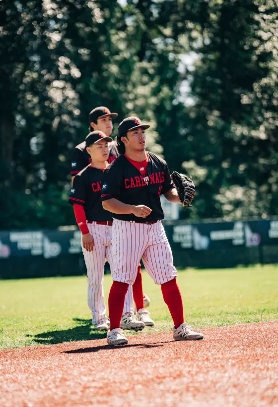 Two Abbotsford Cardinals players walking in off the field together in black kit.