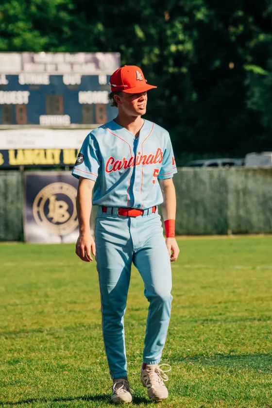 An Abbotsford Cardinals player standing in the outfield, the club's script legible on his jersey.