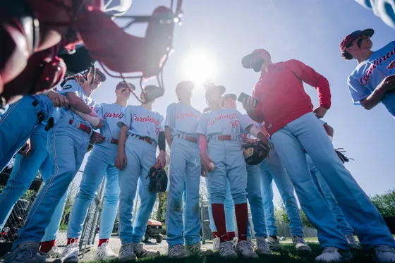 Cardinals players huddle in the sun before a game.