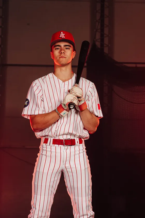 An Abbotsford Cardinals hitter holds a bat across his shoulders in a studio portrait.