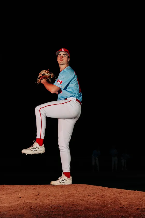 An Abbotsford Cardinals pitcher delivers on the mound in a night portrait.